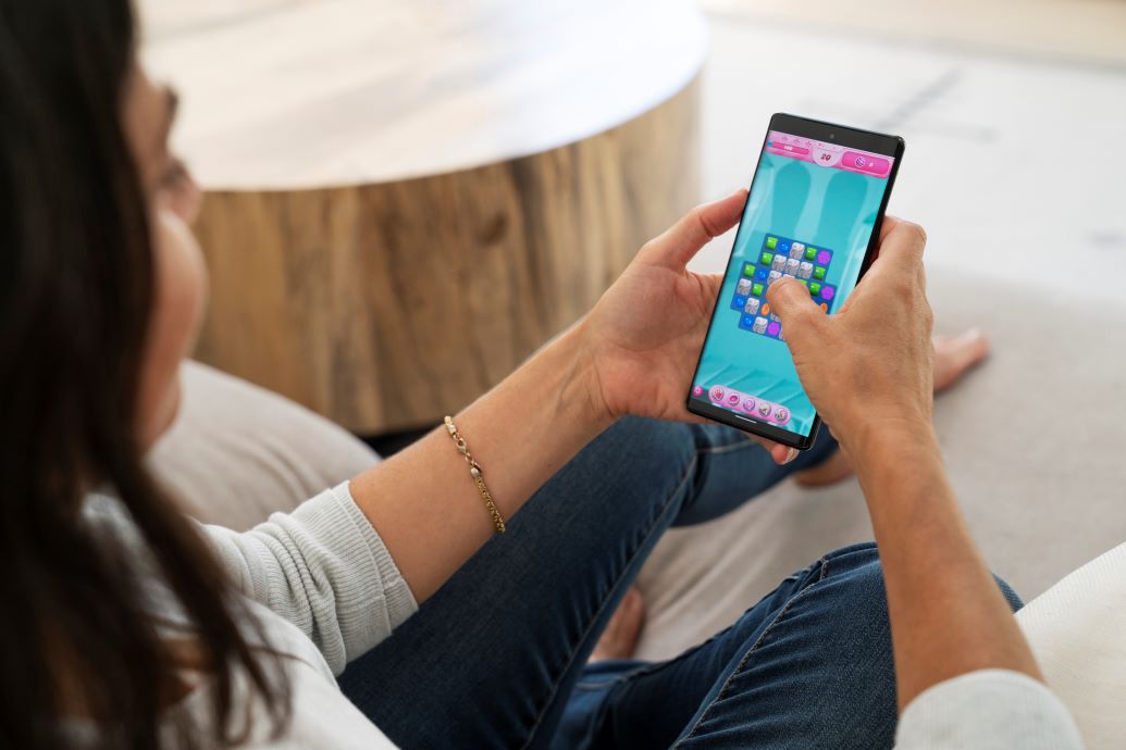 A woman plays Candy Crush in her living room