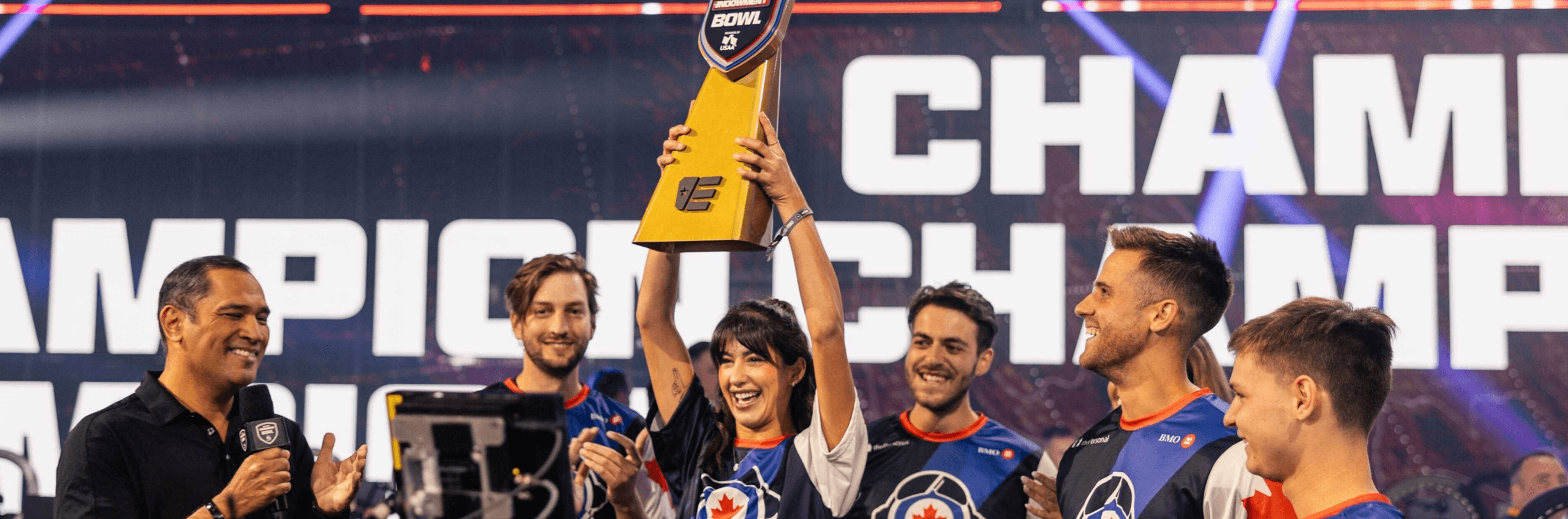 A Call of Duty: Warzone esports team raises a trophy to their victory.
