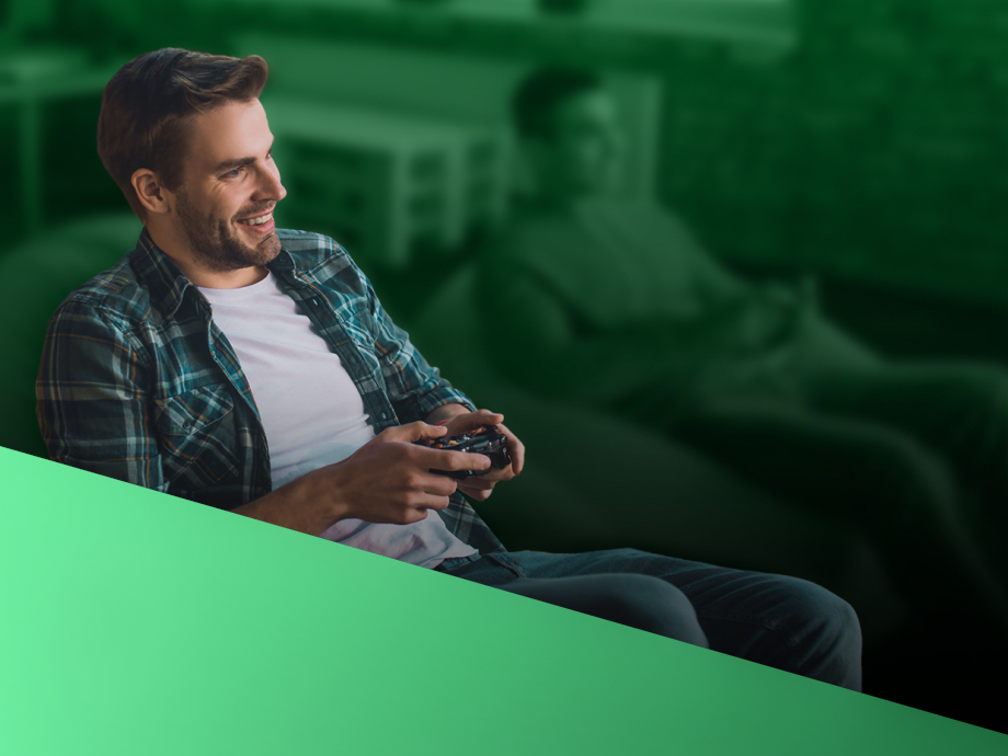 A man plays XBOX happily on his couch.