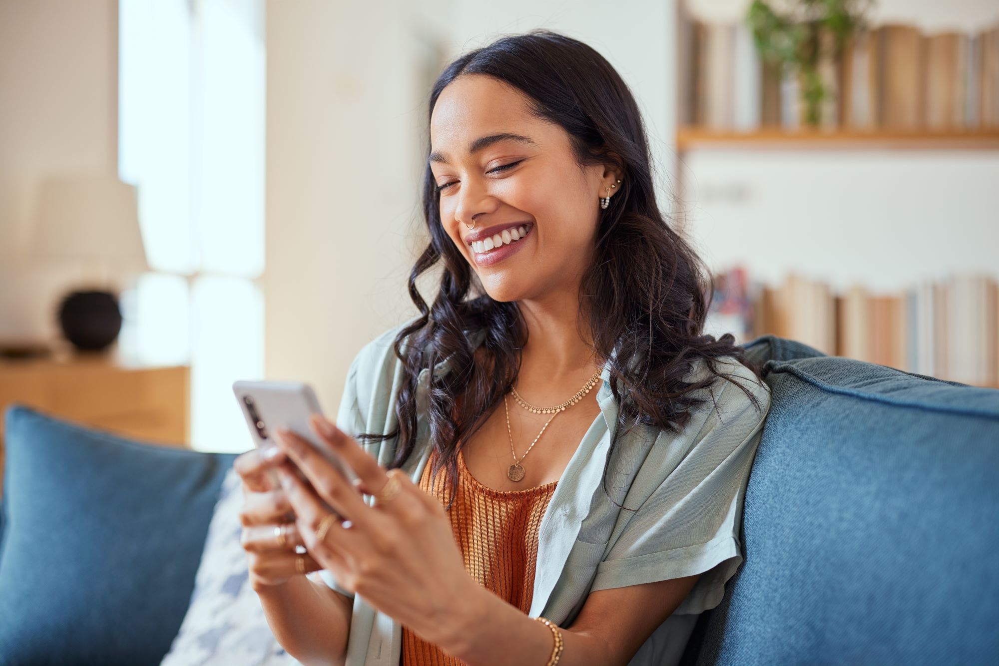 A woman happily gaming on her smartphone.