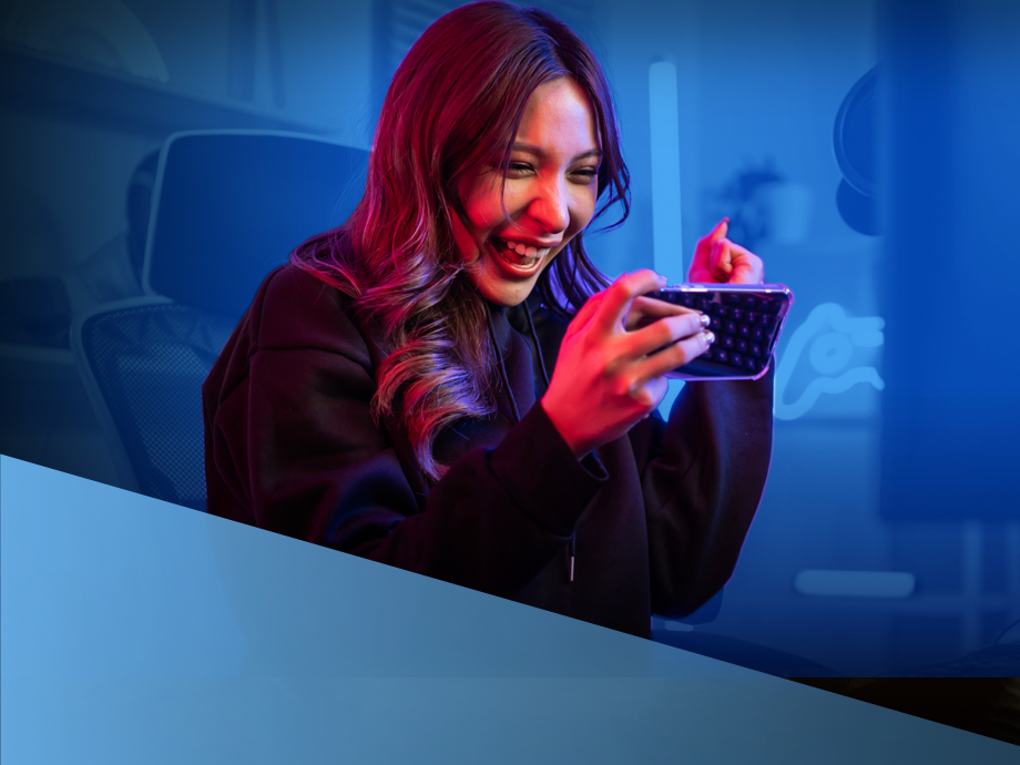 A woman happily gaming on her smartphone.