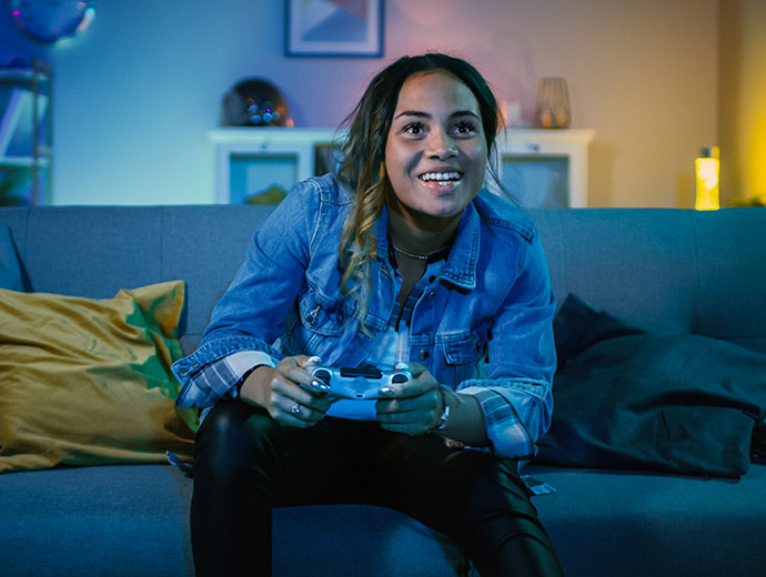 Woman gaming on her couch at home