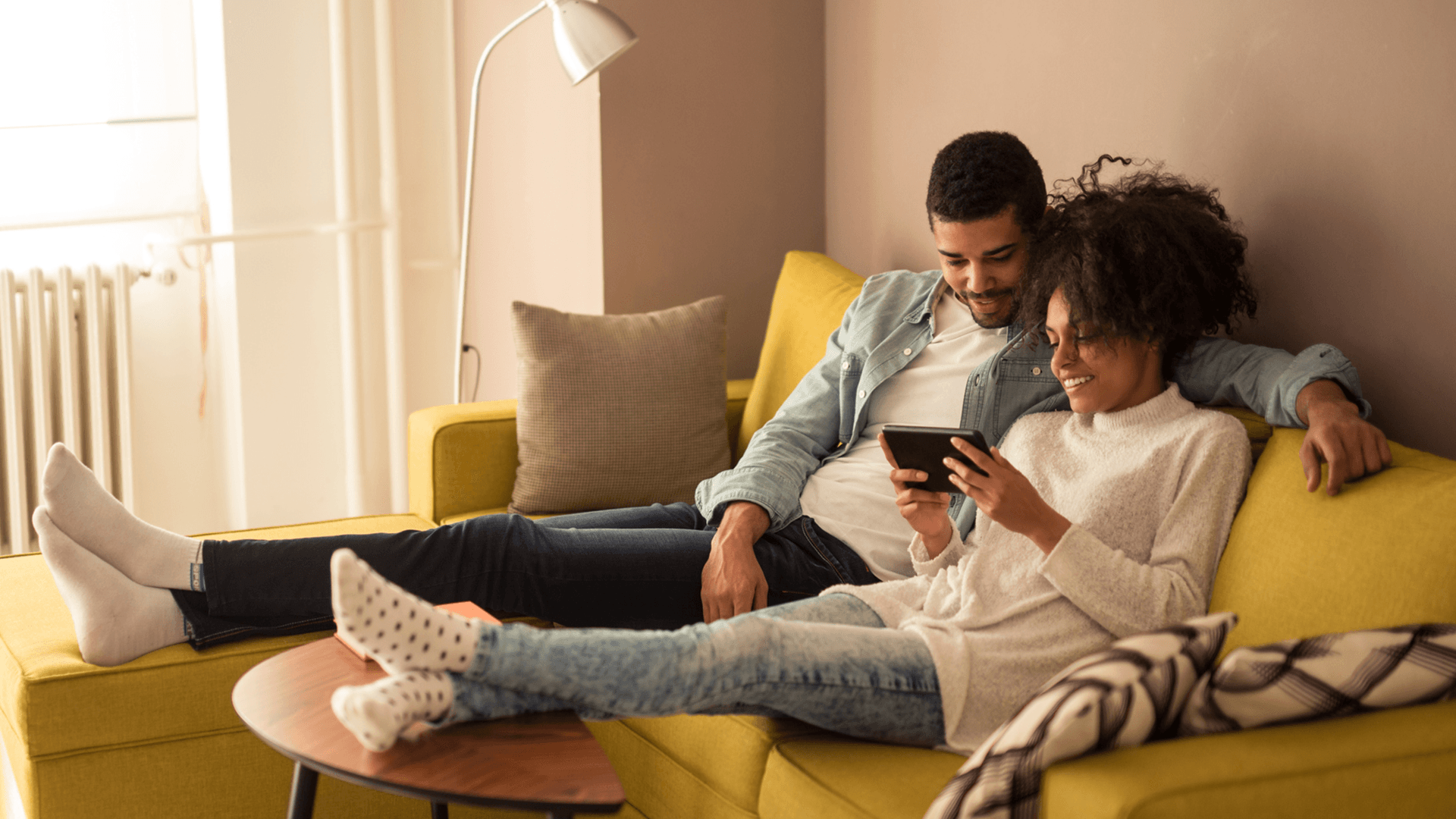 Couple sitting on a couch playing mobile games