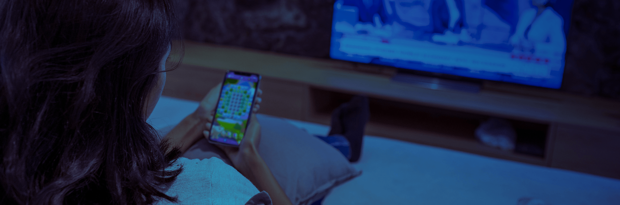 Woman double screening TV and Candy Crush
