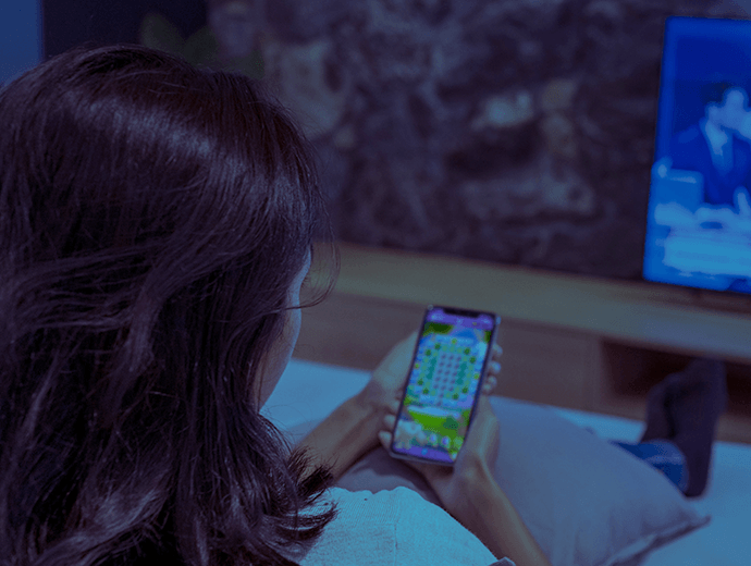 Woman double screening TV and Candy Crush